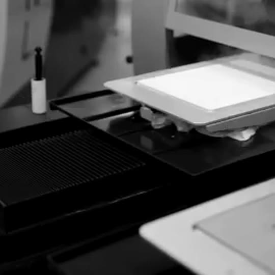 Screen printing press pulling ink onto a t-shirt